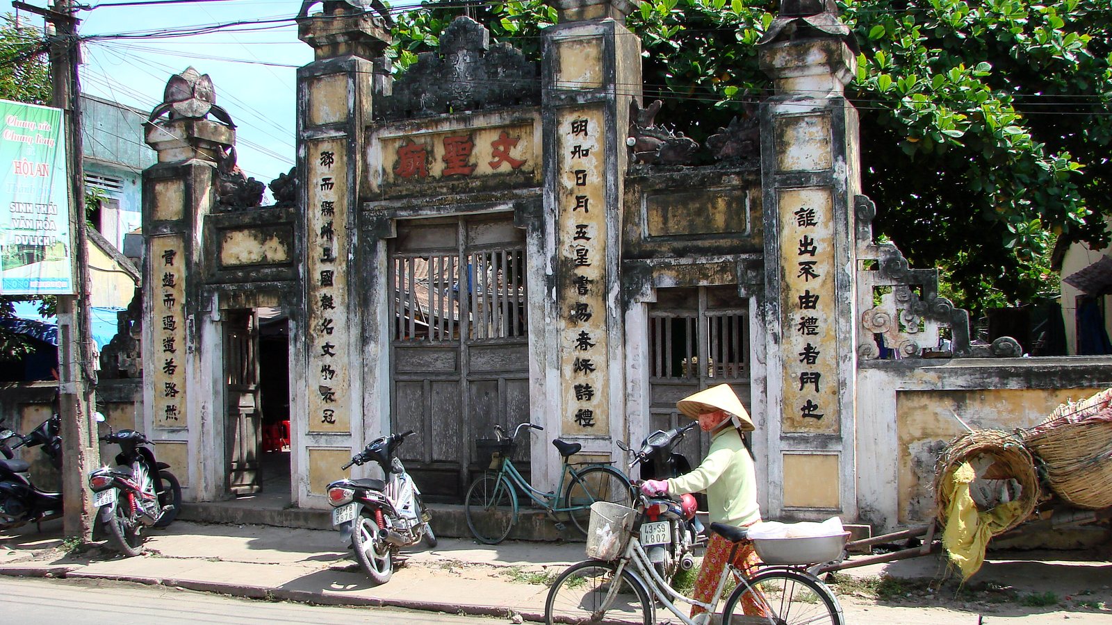 Hoi An street scene with yellow buildings, scooters, and everyday life rather than brochure polish