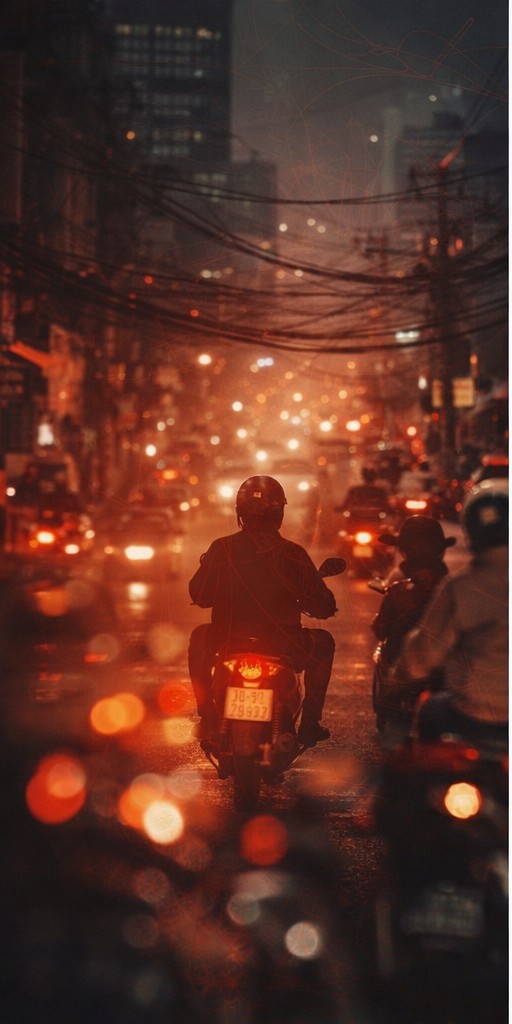 Scooters moving through a dense Vietnamese street at night